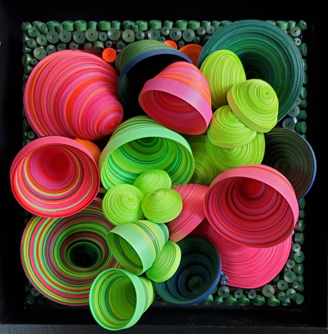 Adventuring with Fuchsia Anxiety: bright fuchsia and lime-green paper cones and spirals against a black background