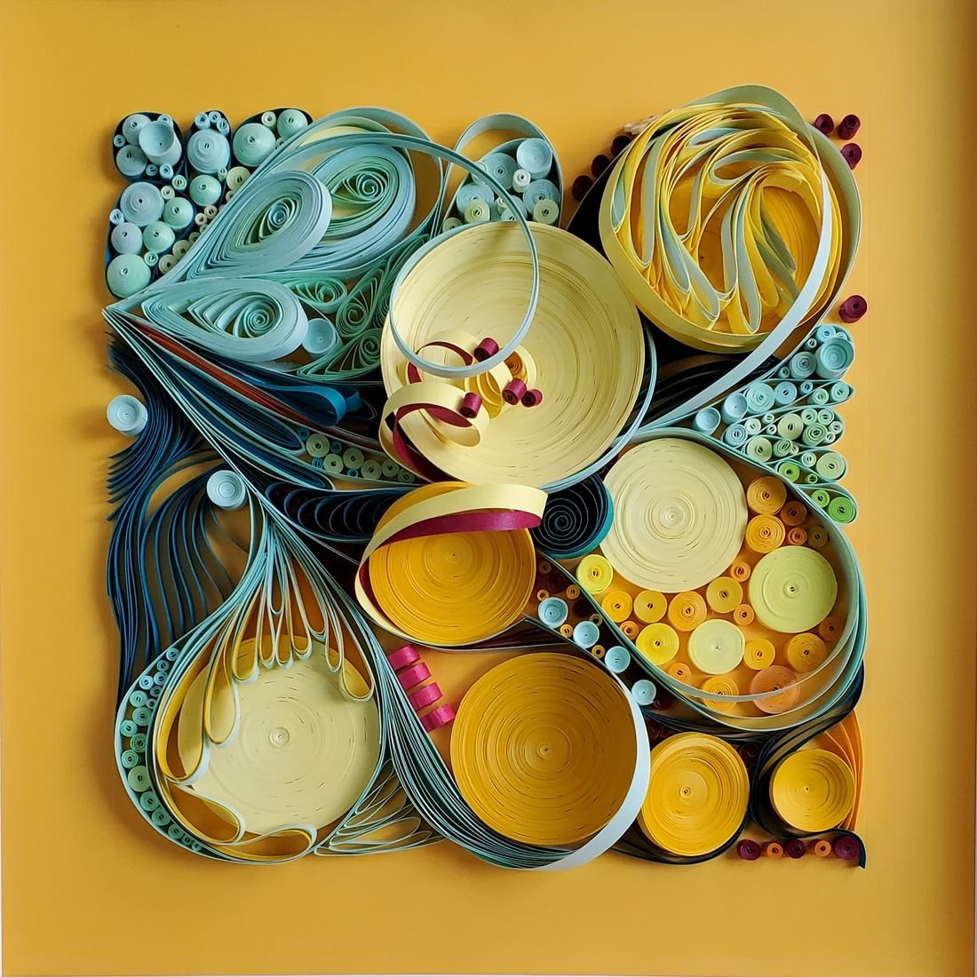 A Moment of Yellow Joy: layered quilled paper with cream, teal and orange spirals on a mustard-yellow background