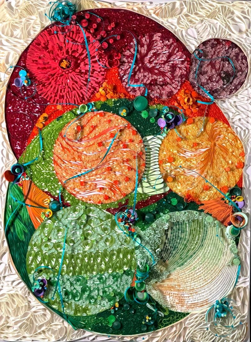 Searching for Teal Harmony: a tall composition of circular paper medallions in orange, red and green with teal ribbon accents