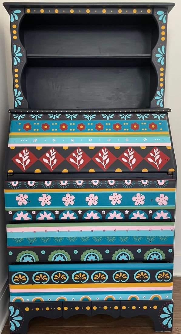 Secretary Desk: a black desk hand-painted with bands of colorful floral and geometric patterns